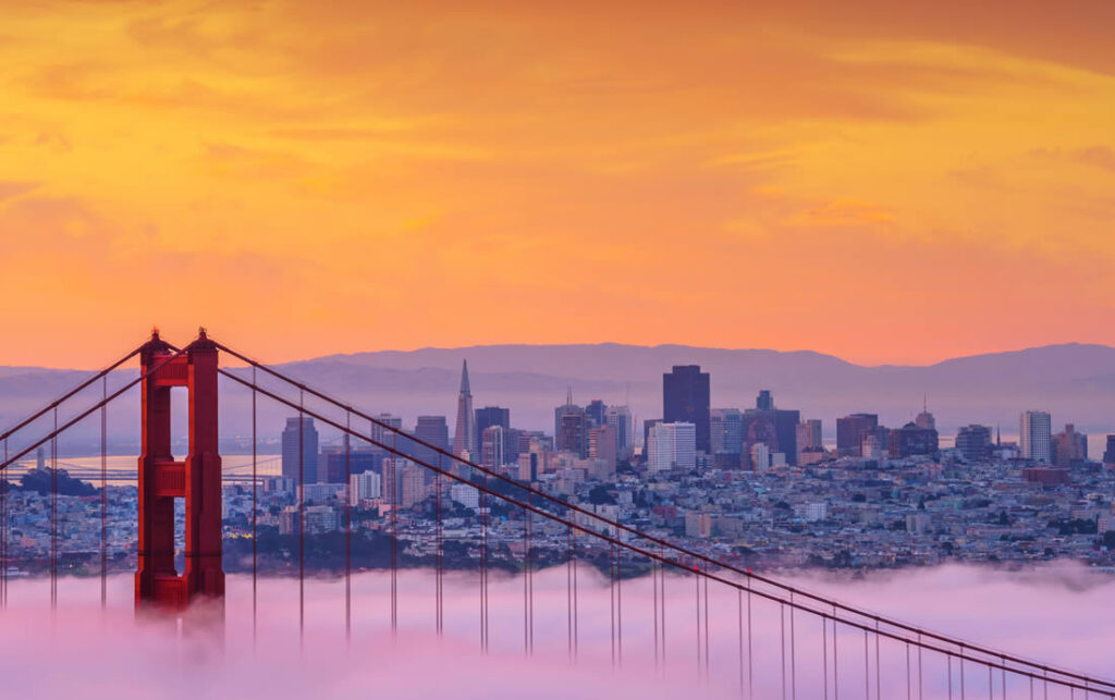 Un coucher de soleil avec un pont et la ville en arrière plan
